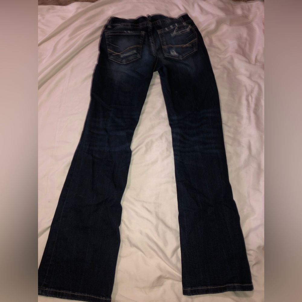 Dark wash bootcut jeans with distressed details